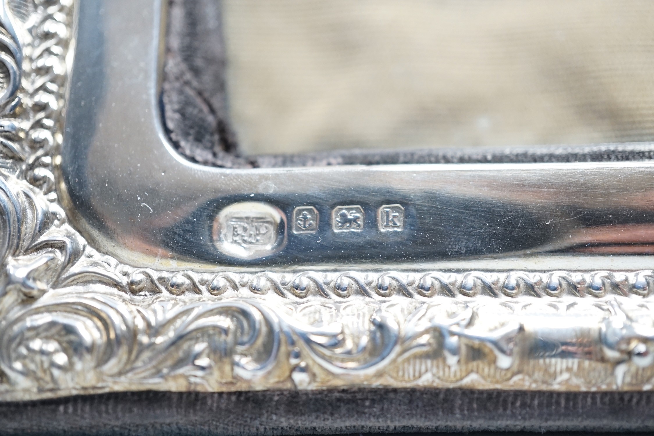 Two silver mounted photograph frames, including Edwardian with repousse border, Birmingham, 1909, 22.2cm.